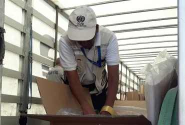 Thevanathan Nadesapillai, UN Volunteer with the United Nations Monitoring Mechanism for Syria (UNMM), checking the contents of a shipment of the International Organization for Migration (IOM) in Turkey.