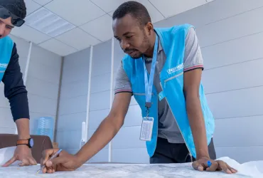 Abdelmohsin Elzair, international UN Volunteer Expert Supervising Engineer with UN-Habitat, inspects a drawing of a project site plan in Basra, Iraq.