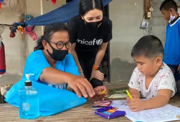 UN-Vounteer-Rasa-Pattikasemkul-interacts-with-a-young-boy-in-a-rare-face-to-face-meeting-during-COVID19-lockdown (1)_0.jpg 