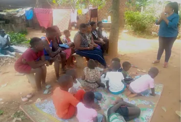 UN Volunteer Arinaitwe Mary Immaculate (standing) during a community sensitization on the Ebola procedures and mental health indicators at Lorinda cell Busabala, Uganda.