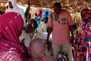 Dr. Mahamadou Nouri Kassimoune Tago, UN Volunteer Specialist, conducts a routine vaccination monitoring session at a WHO vaccination site. 