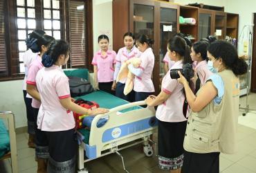 Fatima-Zahra Benyahia (first from right holding a camera), international UN Volunteer Partnerships and Innovation Specialist with UNFPA in Lao PDR, documents UNFPA's work with midwives in Savannakhet, in July 2022. 