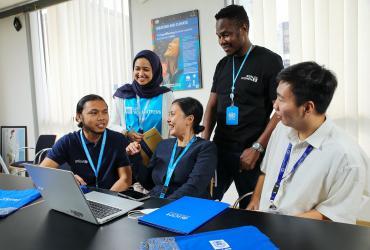 I Made Wikandana (left), national UN Volunteer Disability Inclusion Officer with UNICEF Indonesia, interacts with fellow UN Volunteers at the UN House in Jakarta, Indonesia.