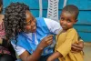 Marriane Enow Tabi, UN Volunteer Monitoring Assistant with the World Food Programme in Meiganga, Cameroon, with a child from the Lolo refugee site.