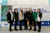 Oksana Vlasenko, UN Volunteer with UNDP Moldova, is standing in front of a backdrop with her colleagues in UNDP Moldova office.