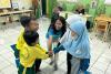 Isna Aulia Fajarini (centre), national UN Volunteer Nutrition Officer with UNICEF, interacts with elementary school children in Jakarta.