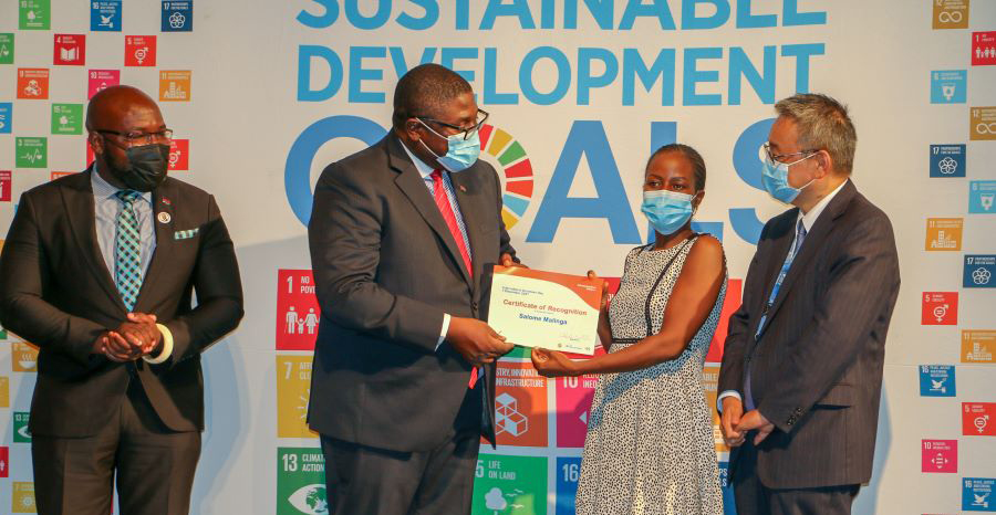 Hon. Roy Akajuwe Kachale-Banda, Minister of Industry, hands over a certificate to a UN Volunteer during the IVD 2021 event on 7 December 2021 in Malawi.