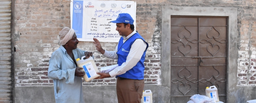 UN Volunteer handing over a product to man